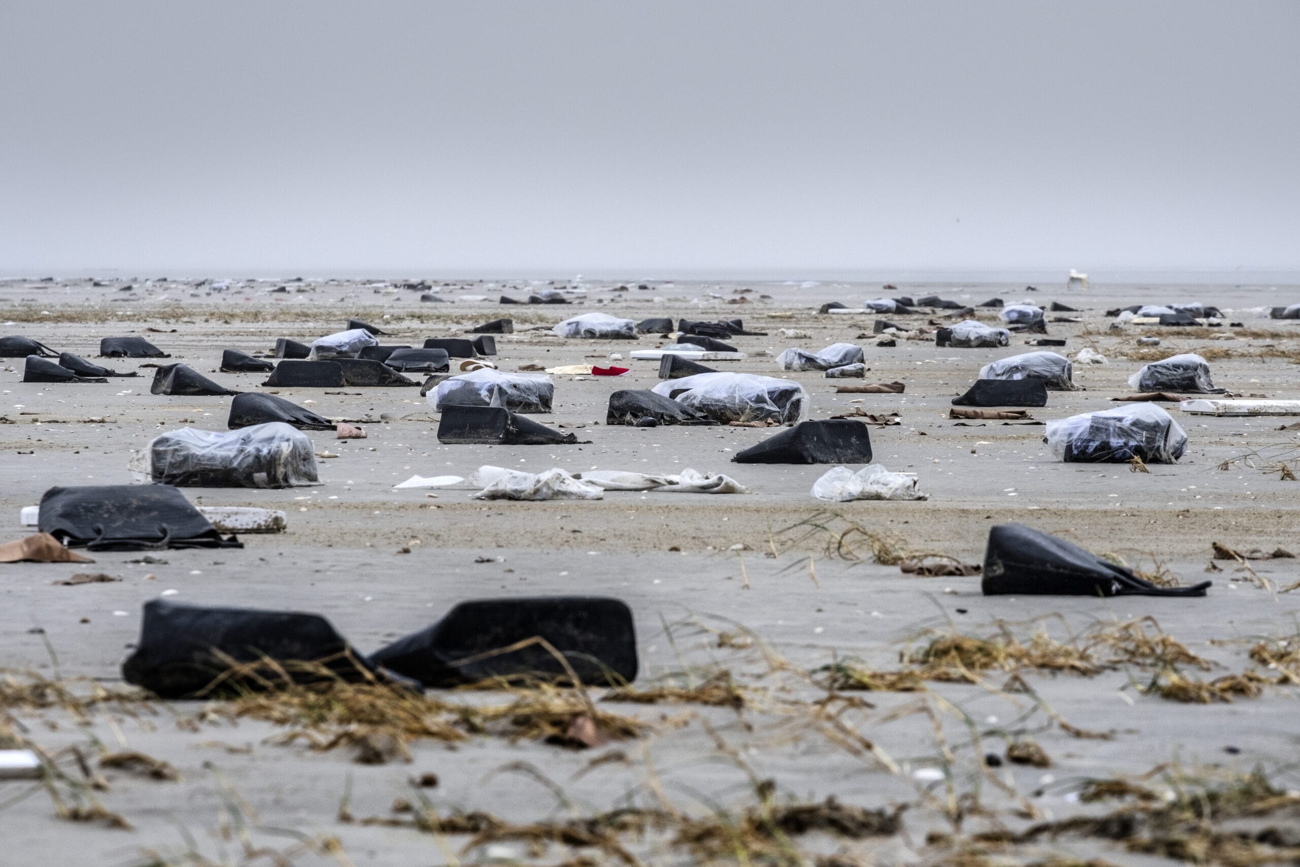 strand bezaaid met tassen, schoenen, en troep