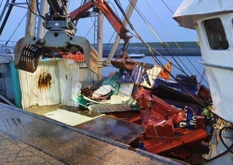 Bergingsboot met containerresten en ander afval